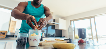 Atleta preparando alimentos nutritivos para seguir dieta de alto rendimiento.