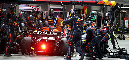 Grupo de mecánicos trabajando en el auto de F1 de Red Bull Racing en los boxes.