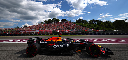 Auto de F1 de Red Bull Racing pasando delante de una grada llena de aficionados.