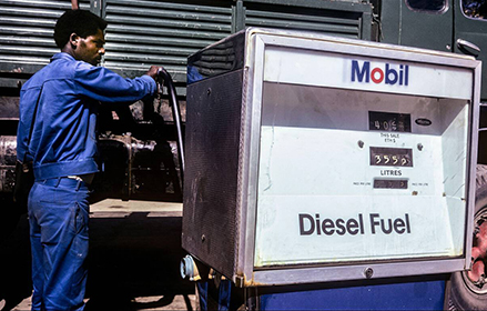 Hombre llenando su camión diésel en una estación de Mobil