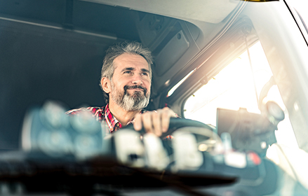 Camionero conduciendo con el sol entrando por la ventanilla del camión