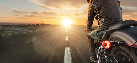 Motocicleta sobre carretera al atardecer