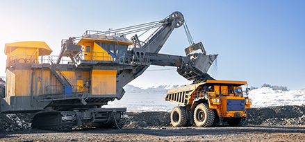Maquinaría de minería al aire libre de silos, cintas transportadoras y camiones de volteo.