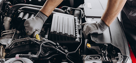 Mecanico con guantes revisando un motor para solucionar el sobrecalentamiento